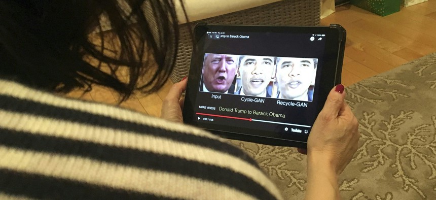 A woman in Washington, D.C., views a manipulated video former presidents Donald Trump and Barack Obama.
